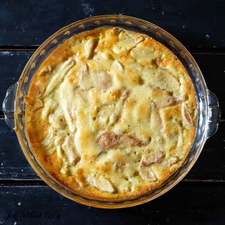 Baked chicken and mushroom casserole in a glass dish on a dark wooden surface.