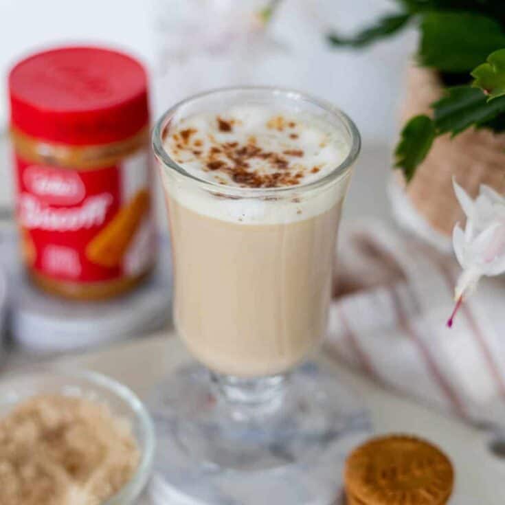 Frosted coffee drink with whipped cream and cocoa powder on top.