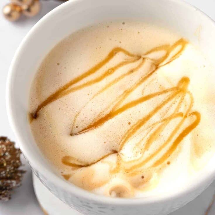 Creamy caramel latte hot beverage with caramel drizzle, cozy coffee drink.