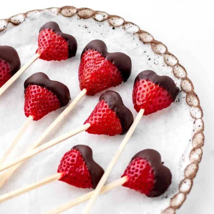 Fresh strawberries dipped in chocolate on a buffet platter.