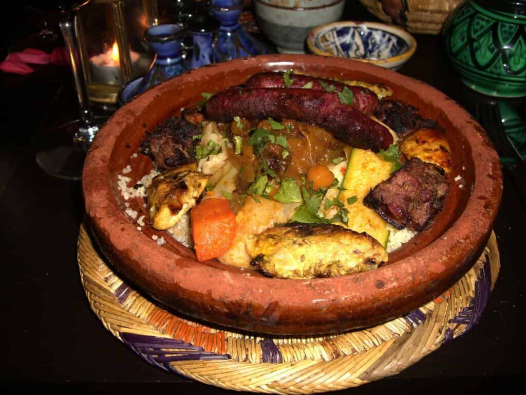 Slow-cooked Moroccan tagine with lamb, vegetables, and spices in traditional clay dish.