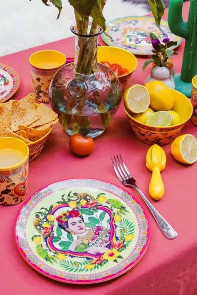 Colorful Mexican-inspired table setting with vibrant dishware and fresh lemons.