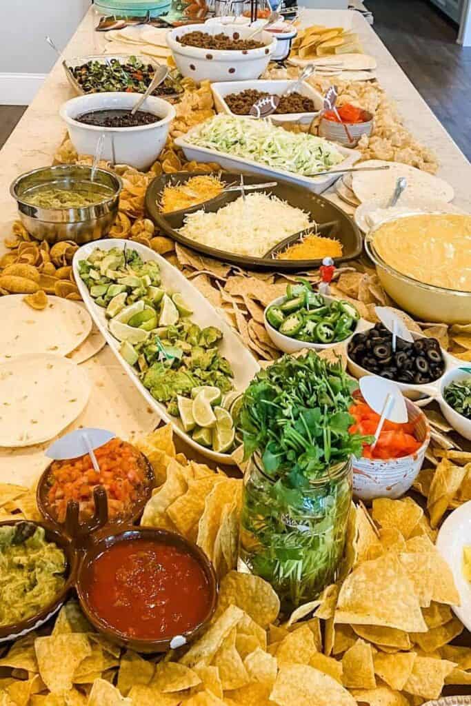 Colorful taco salad bar with fresh vegetables, toppings, and condiments at The Olive Branch Nest.