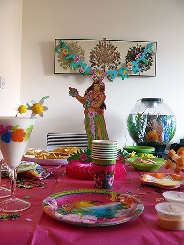 Colorful fiesta party table with tropical decorations and festive themed tableware.