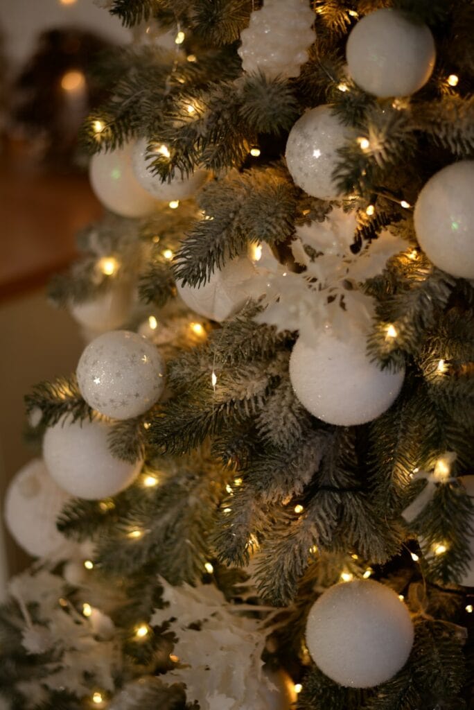 a decorated christmas tree with white and gold ornaments