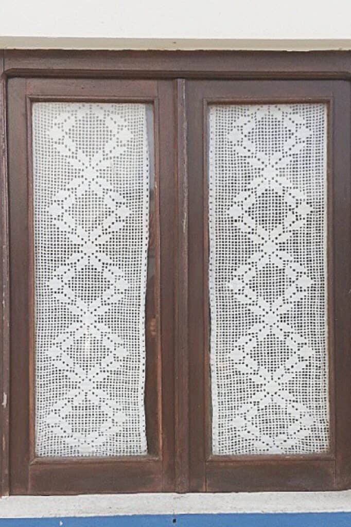 Intricate wooden cabinet doors with lace patterned panels for rustic home decor.