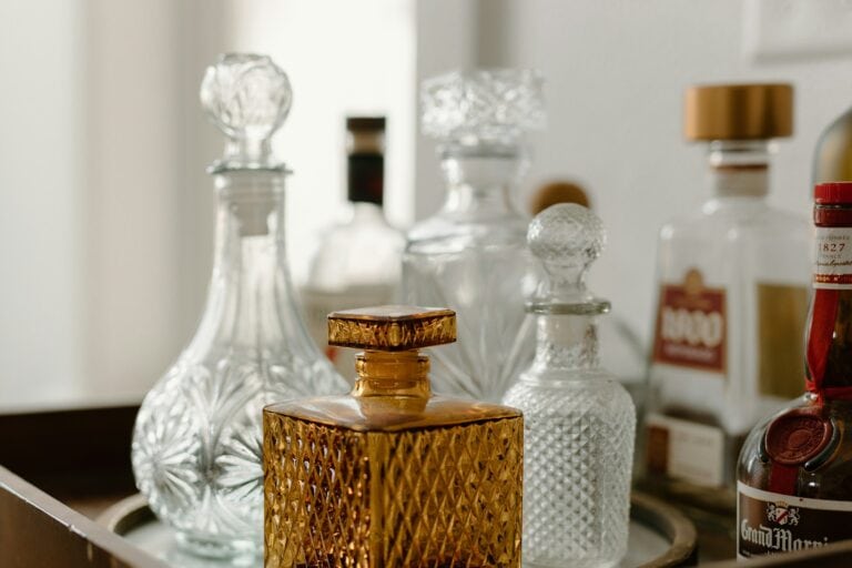 A collection of vintage glass perfume bottles with intricate patterns and elegant stoppers.