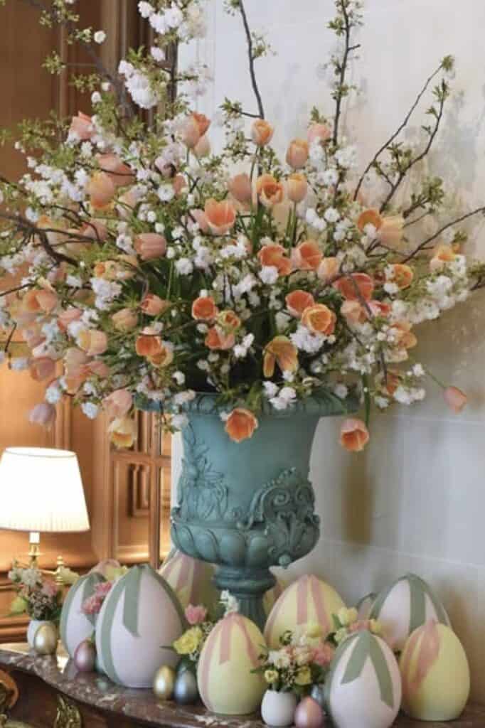 Vivid floral display featuring peach tulips and white baby's breath in an elegant vase.