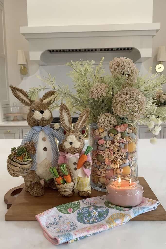 Cute bunny Easter figurines with carrots and floral arrangement in jar.