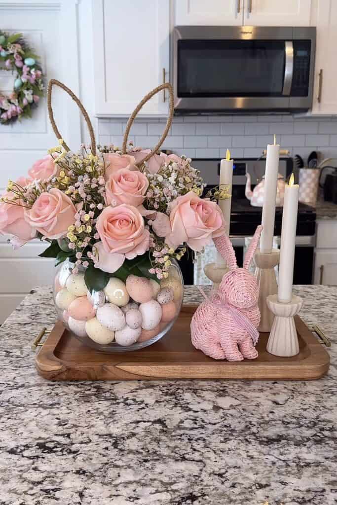Easter-themed pink rose and egg floral centerpiece on kitchen counter.