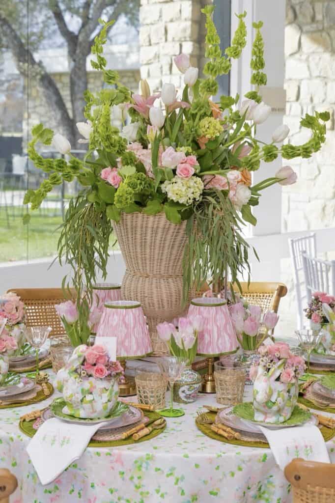 Bright floral centerpiece with pink tulips, roses, and greenery for spring events.
