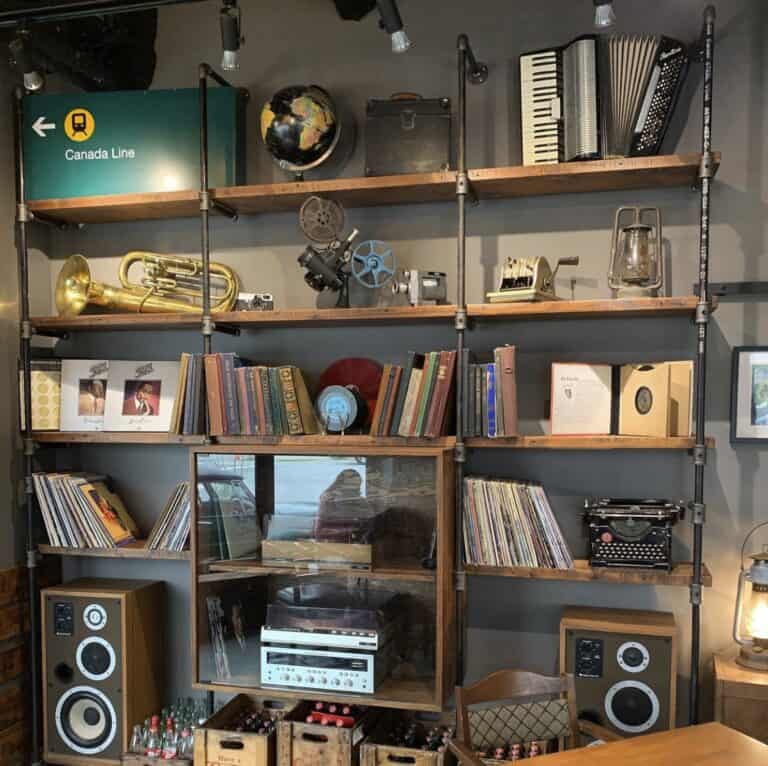 Vintage music and book shelf with record player, speakers, and retro decor in cozy space.