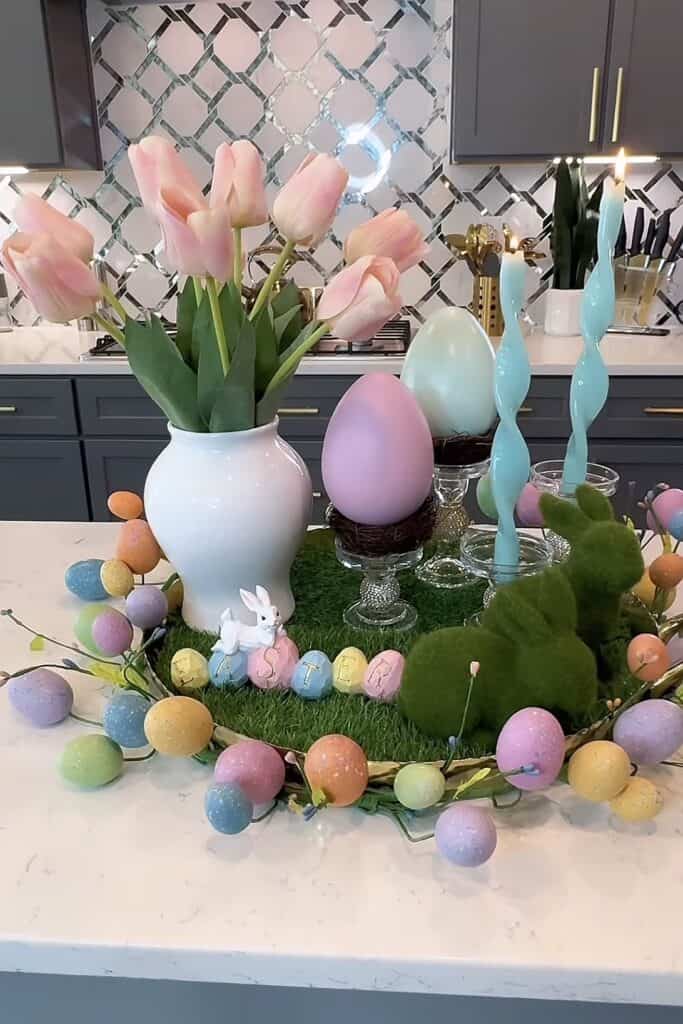 Easter table centerpiece with pastel eggs and blooming tulips.