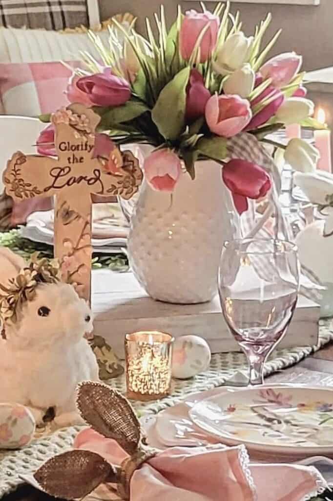 Vase with pink tulips and white roses with table setting.