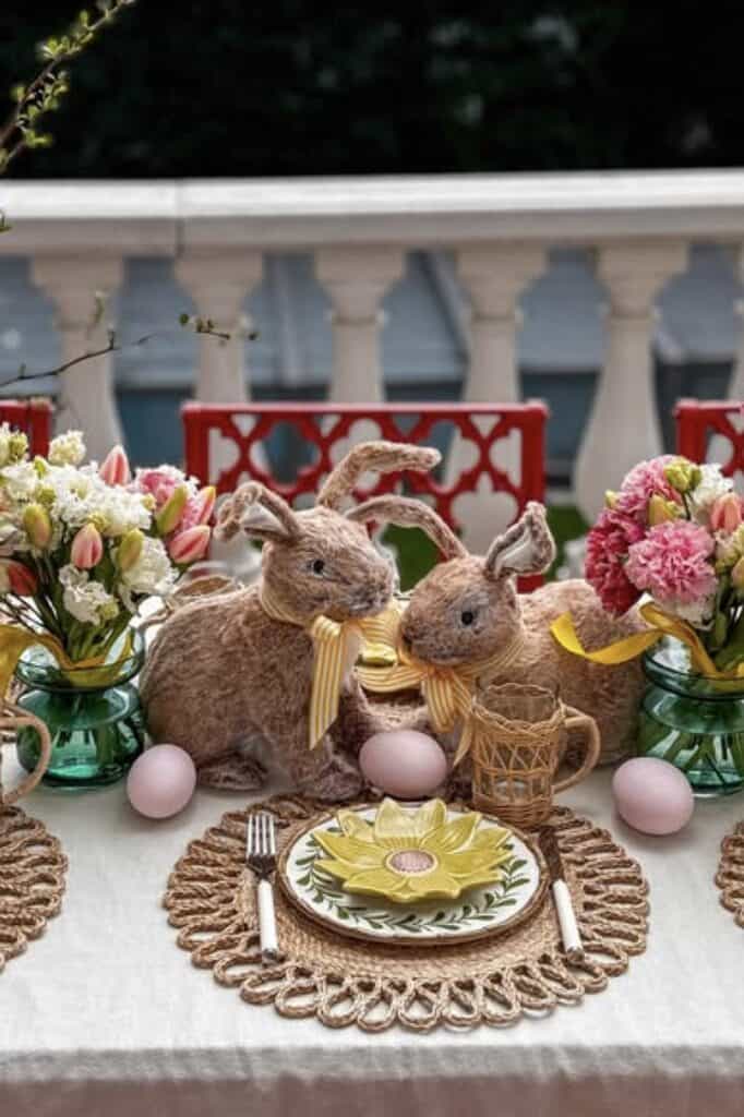Colorful Easter table decor featuring plush bunny toys, fresh flowers, and decorative eggs.