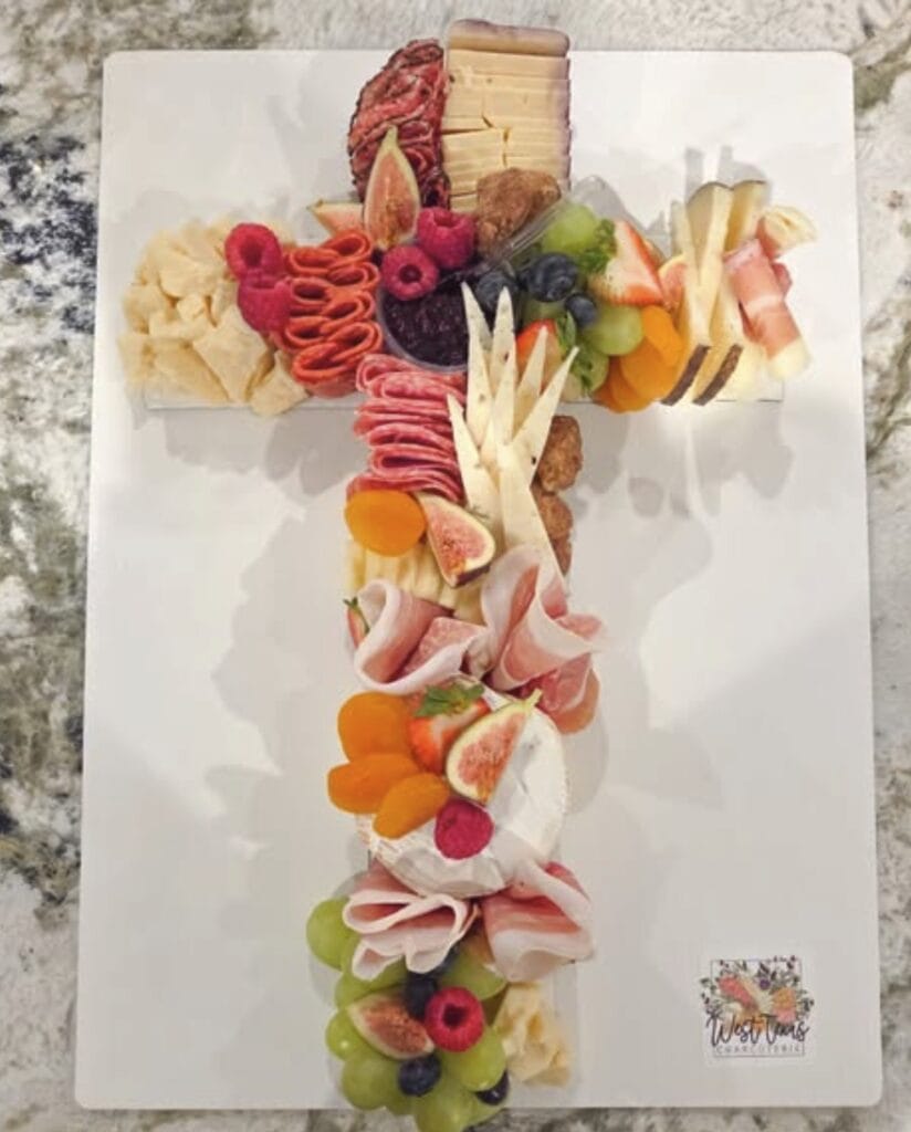 Vibrant cheese, fruit, and meat platter on white serving board.