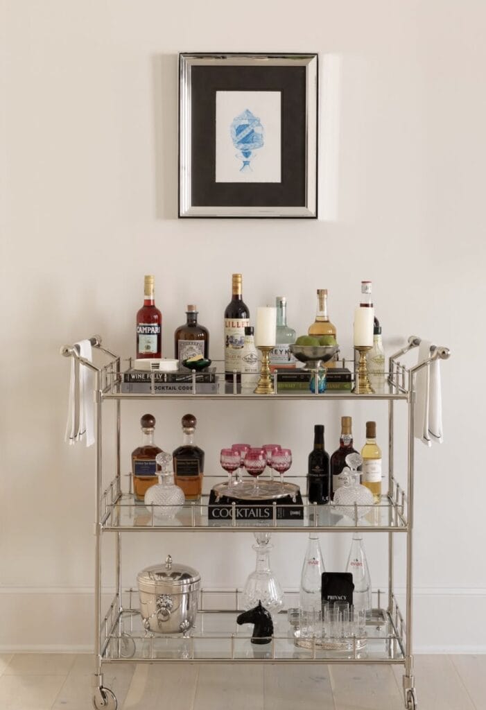 A stylish home bar cart with liquor bottles, glassware, and cocktail accessories for entertaining.