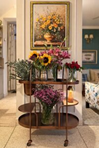 Beautiful floral display with sunflowers, lilies, and roses on a stylish bar cart.
