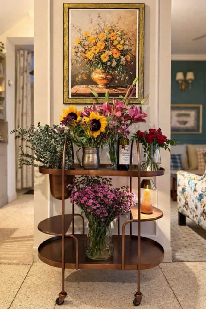 Beautiful floral display with sunflowers, lilies, and roses on a stylish bar cart.