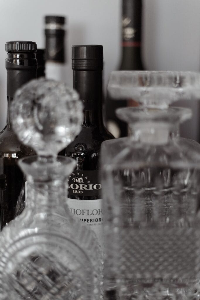 Decorative glass decanters and bottles for home bar organization.