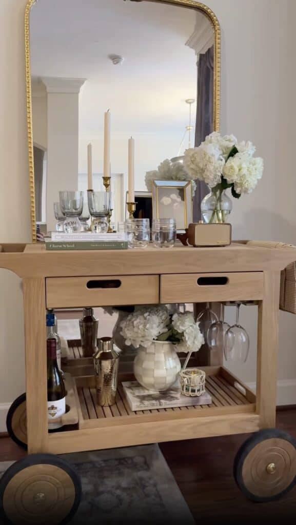 Beautiful wooden bar cart with floral arrangement, glassware, and accessories for stylish home bar s.