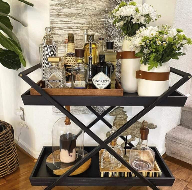 Elegant bar cart with liquor bottles, flowers, and decorative accessories.