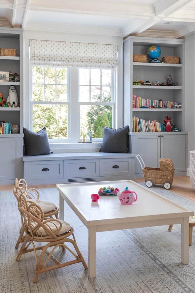 Bright playroom with built-in window seat, shelves, and storage for kids.