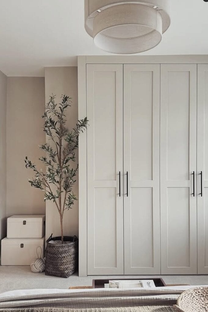 Built-in bedroom closet with white doors and minimalist design.