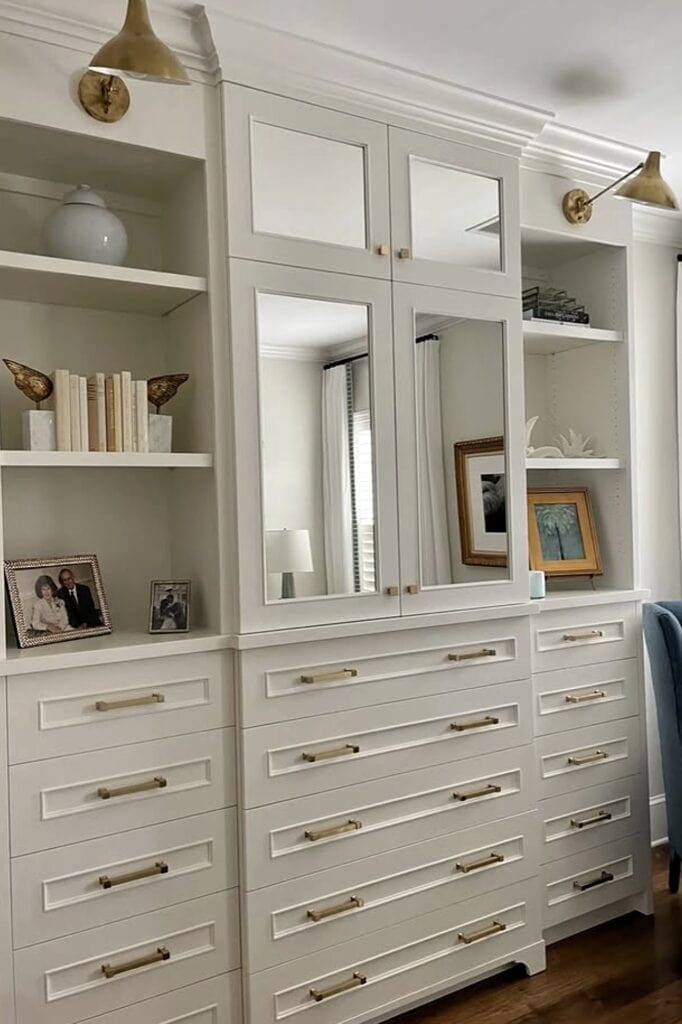 Elegant white built-in bedroom storage unit with drawers and mirrored cabinets.