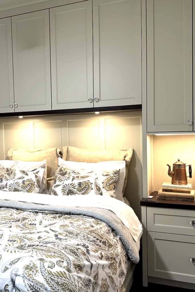 Built-in bedroom storage with beige cabinets and decorative pillows.
