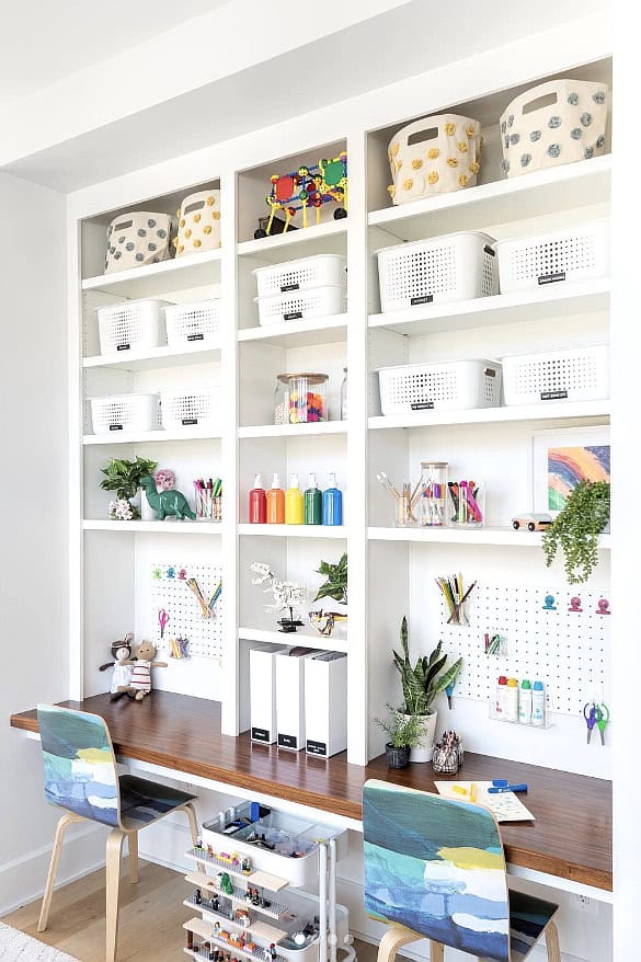 Built-in playroom storage with baskets, bins, and colorful toys for organization.