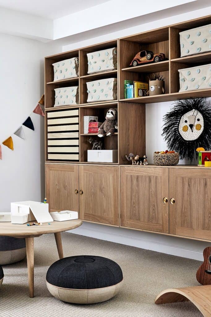 Built-in playroom storage unit with cubbies, toys, and decorative accents.