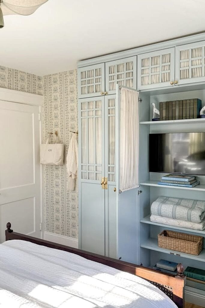 Built-in bedroom closet with light blue cabinetry and organized shelves.