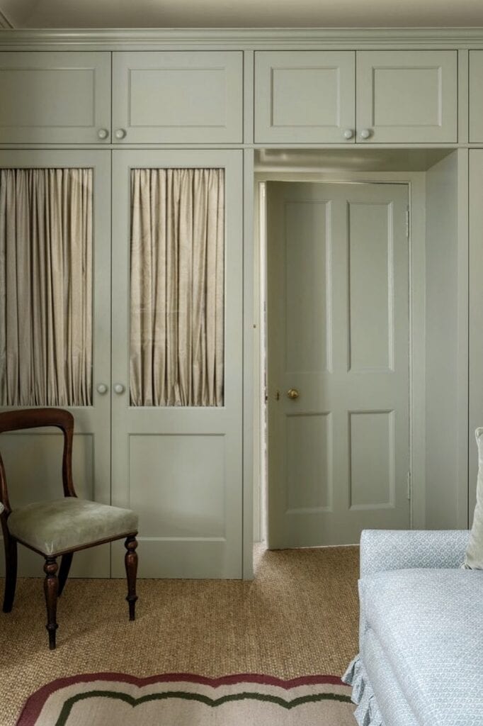 Built-in bedroom storage with cabinets and curtains for a cozy, organized space.