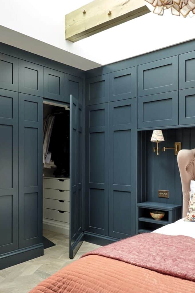 Built-in bedroom closet with blue cabinetry and organized storage.