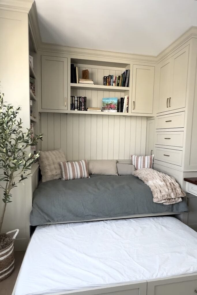 Custom built-in storage and seating area in a bedroom with white cabinetry and cushions.