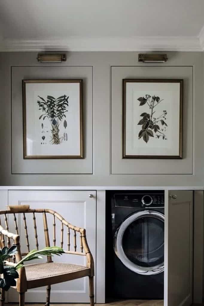 Decorative botanical prints above a laundry machine in a modern bedroom.