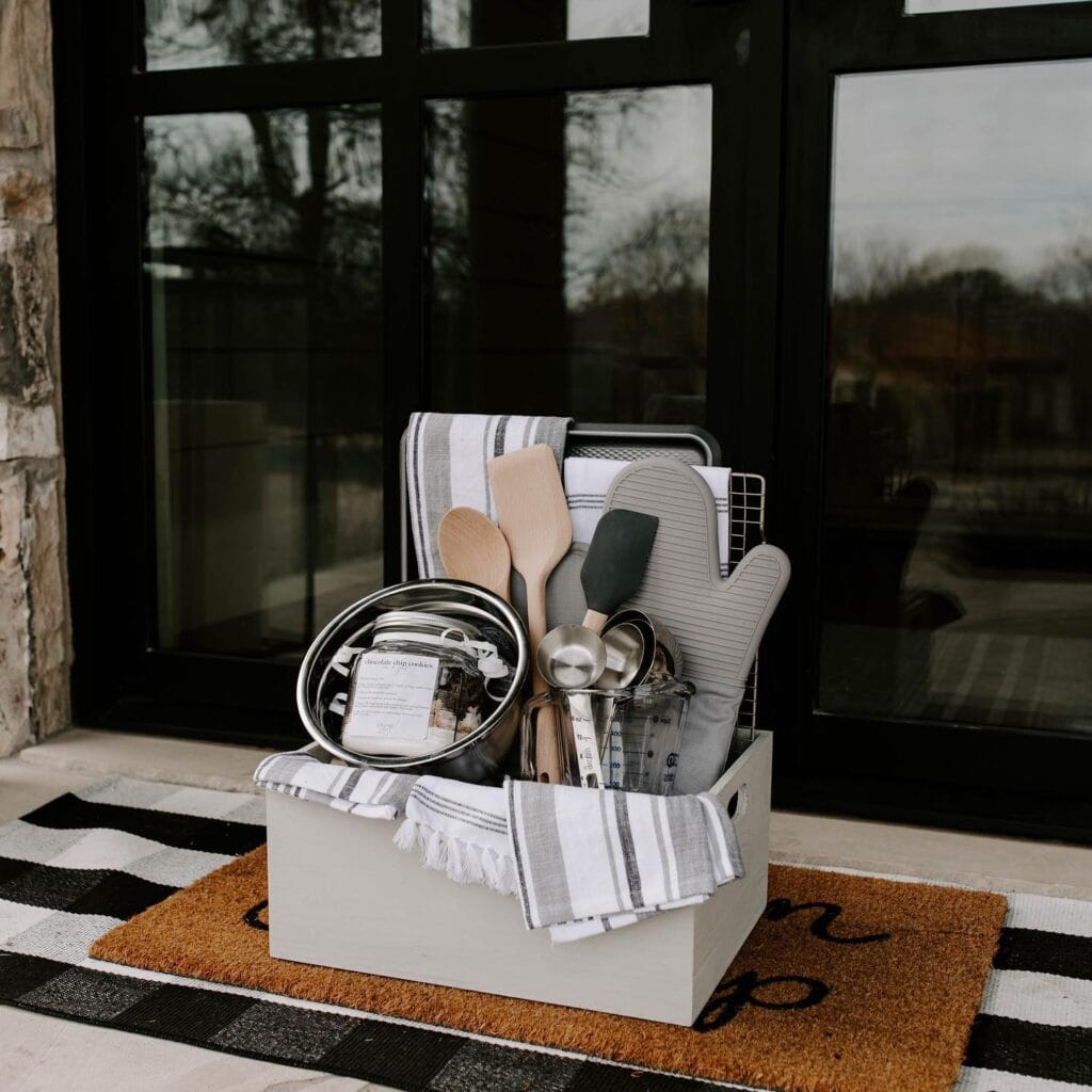 A set of kitchen utensils including spoons, spatulas, and tongs in a storage box on a porch.