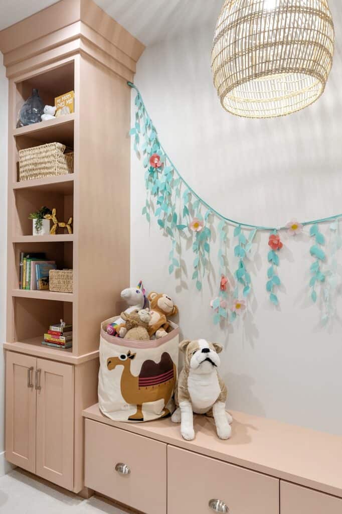 Bright playroom built-in storage with plush toys, decorative garland, and cozy ambiance.