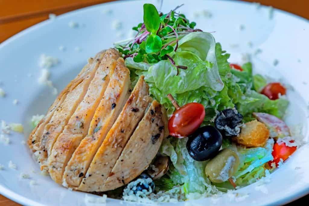 Healthy high-protein chicken salad with fresh greens and vegetables.