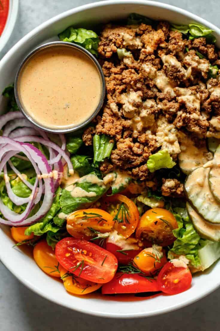Healthy beef salad with cherry tomatoes, cucumbers, onions, and dressing.