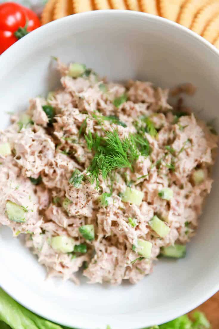 Fresh tuna salad with celery and herbs in a white bowl, healthy and delicious.