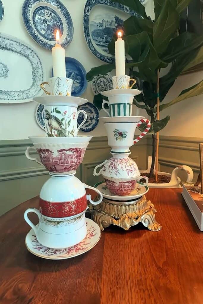 Decorative teacup candles with stacked cups and lit candles for holiday decor.