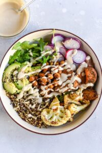Fresh high-protein salad with vegetables, grains, and dressing.