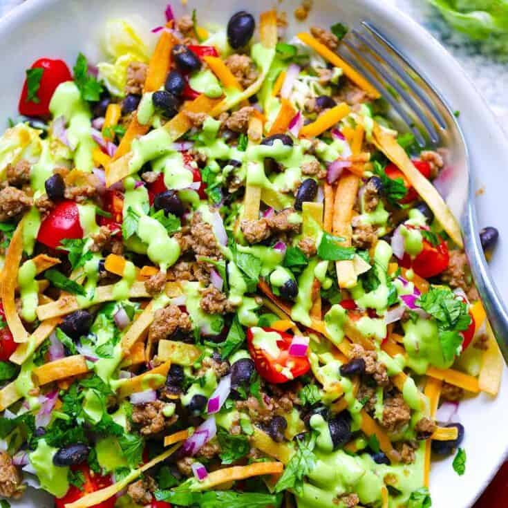 Vibrant taco salad with ground beef, black beans, cherry tomatoes, and shredded cheese.
