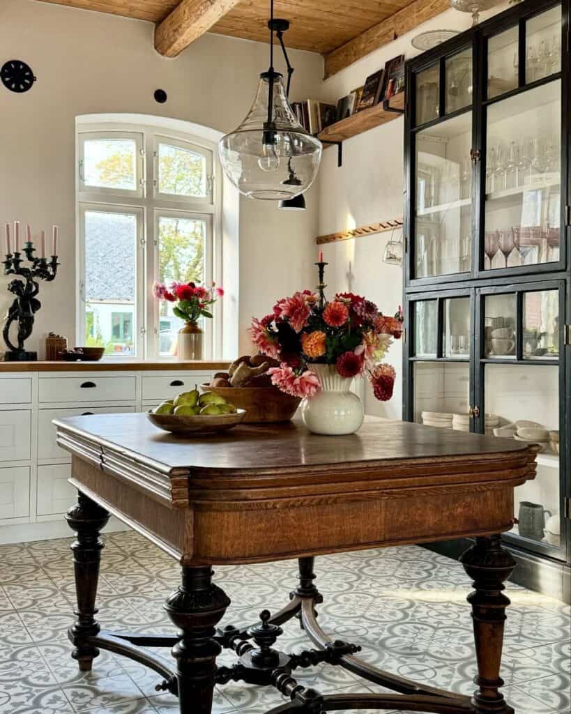 Elegant vintage kitchen table with floral centerpiece and natural light.