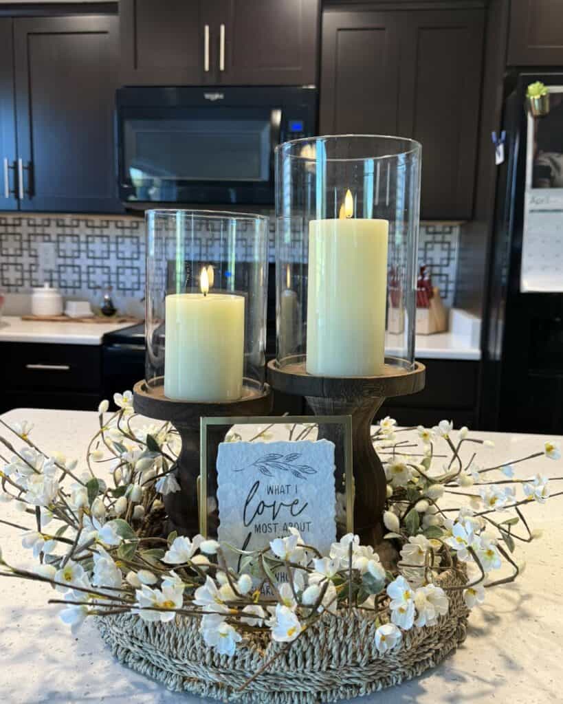 Decorative candle centerpiece with white flowers for kitchen table decor.