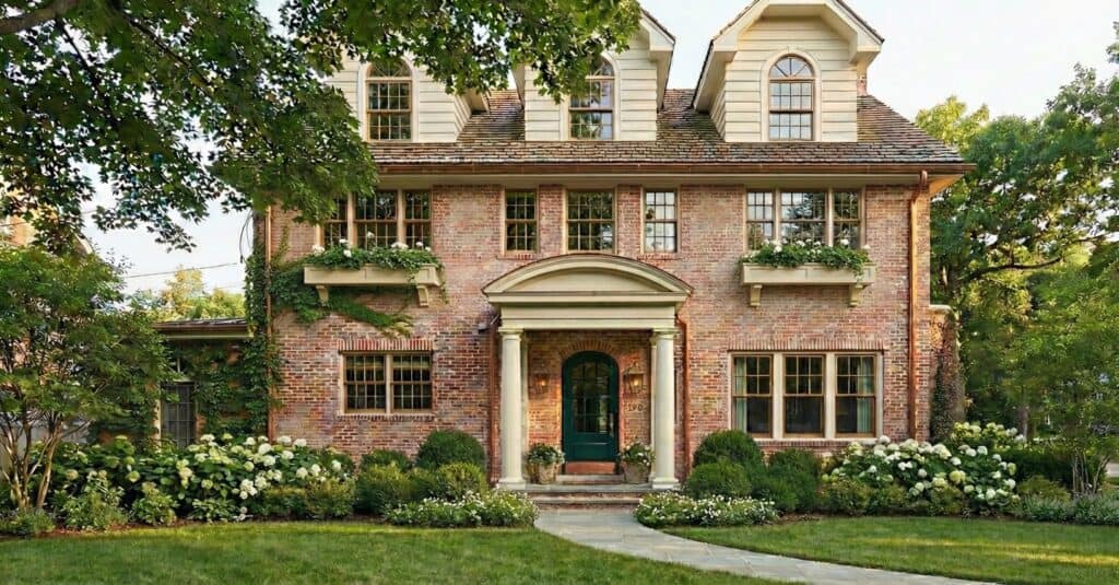 Beautiful brick house with lush greenery, classic architecture, and well-maintained garden.