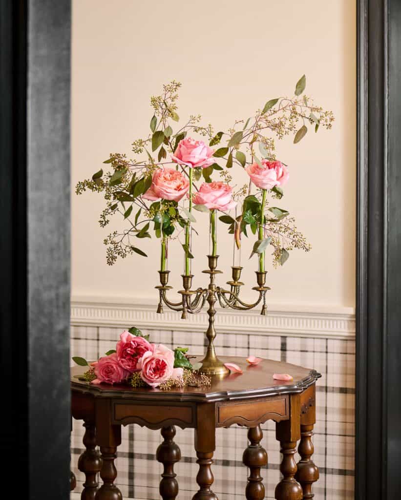 Beautiful floral arrangement with pink roses and greenery on a wooden table.