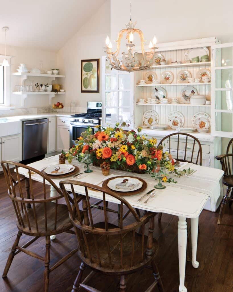 Colorful floral centerpiece on a white dining table in a cozy kitchen setting.